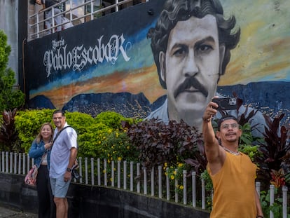 Varios turistas recorren las calles del barrio Pablo Escobar y se hacen fotos con los murales, en Medellín, Colombia, el 21 de noviembre de 2023.
