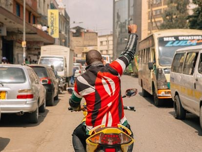 Boniface Mwangi conduce una motocicleta en el barrio de Stahere, en Nairobi, durante los actos de campaña electoral para los que se postuló como parlamentario.