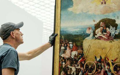 Un instalador ayuda a mover 'El carro de heno' del maestro flamenco El Bosco en el Museo Boijmans van Beuningen en Róterdam.