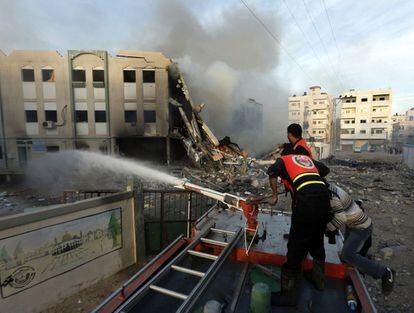 Bomberos palestinos intentan apagar el fuego tras un ataque aéreo israelí en el Ministerio del Interior en la ciudad de Gaza el 16 de noviembre