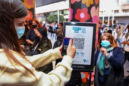 Un cliente escaneando un código QR para ingresar a una tienda departamental en Melbourne, Australia