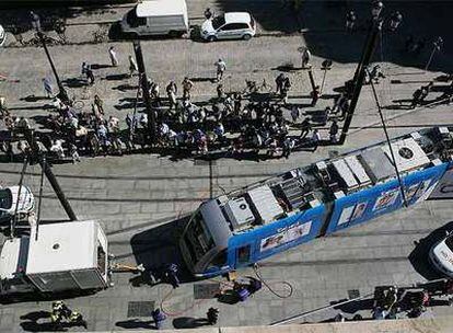 Los operarios del tranvía de Sevilla trabajan para devolverlo a la vía tras descarrilar un convoy.