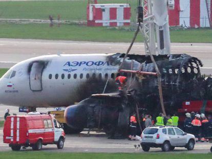 FOTO: Una grúa mueve el Superjet 100 de la pista en el aeropuerto de Moscú. / VÍDEO: El accidente del avión.