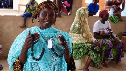 Una de las mujeres que forma parte de la ONG WIG en el pueblo de Njau muestra los collares que acaba de confeccionar con gomas de ruedas de bicicletas.