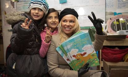 Pamela Anderson, junto a dos ni&ntilde;as en el campo de refugiados en Francia. 