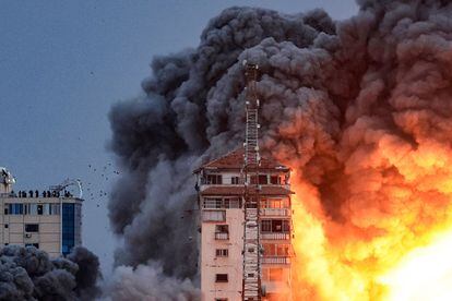 Un grupo de personas observa desde la terraza de un edificio los daños ocasionados por un bombardeo israelí en Gaza el 7 de octubre. 