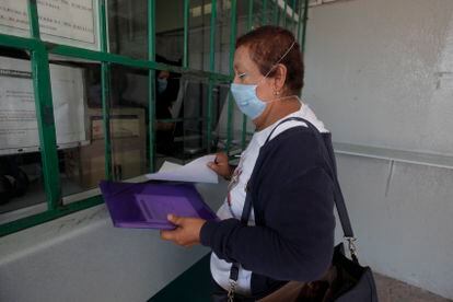 Una mujer de la tercera edad realiza un trámite en una clínica del IMSS en Querétaro.