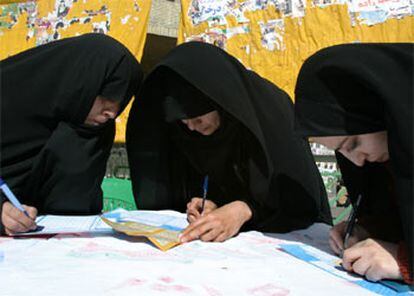 Dos mujeres iraníes rellenan sus papeletas.