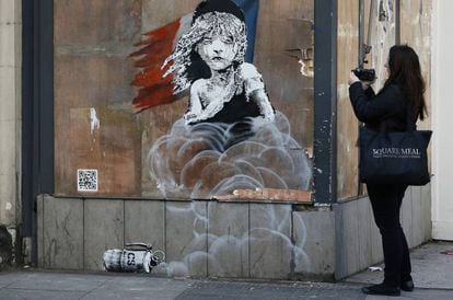 Una mujer observa el grafiti de Banksy que apareció en enero frente a la embajada francesa en Londres.