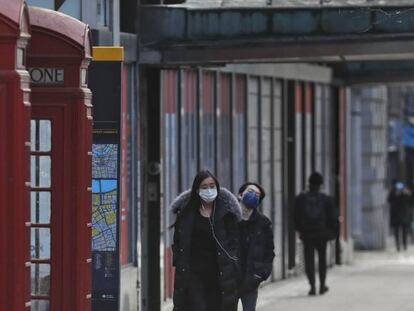 Varias personas andan por las calles vacías de Londres, que tiene cerrados los establecimientos por la pandemia.