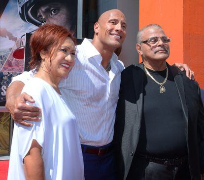 Johnson posa con su padre, el luchador profesional Rocky Johnson, y su madre, tras estampar la huella de sus manos en el Teatro Chino de Los Ángeles en 2015.