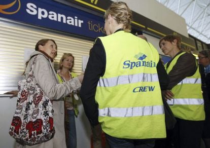 Varios trabajadores de Spanair conversan junto a la oficina de atención al cliente de la compañía en el aeropuerto de Gran Canaria.