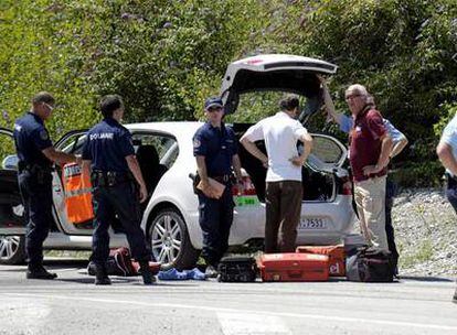 La gendarmería francesa registra el coche de Johnny Schleck (con gafas y camiseta burdeos).