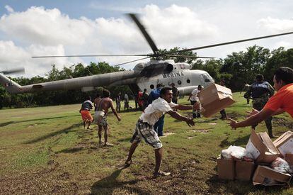 Los evacuados ayudan a descargar cajas de provisiones de un helicóptero de la Marina Mexicana en las cercanías de Acapulco, en el Estado de Guerrero, México.