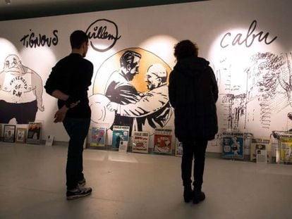 Dos asistentes de la exposición 'Una historia de Charlie Hebdo'.