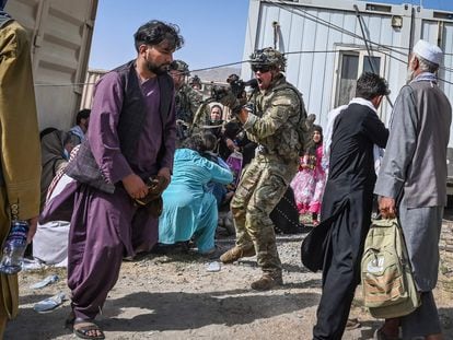 Un soldado estadounidense apunta a un afgano en el aeropuerto de Kabul el 16 de agosto de 2021, en plena salida de las tropas estadounidenses del país asiático.