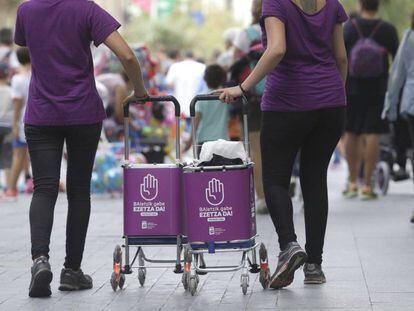 Dos mujeres participan en la campaña informativa contra la violencia sexista en las fiestas de San Sebastian.