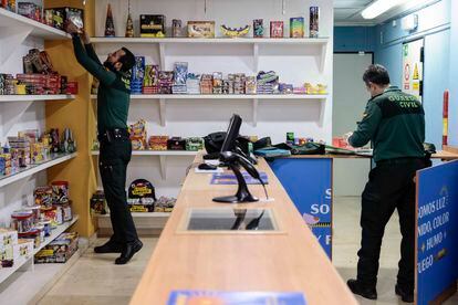 Dos guardias inspeccionan un comercio al por menor de venta de artículos pirotécnicos situado en el barrio de Russafa, en Valencia.
