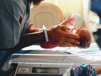 Un enfermero coge a un bebé recién nacido. 