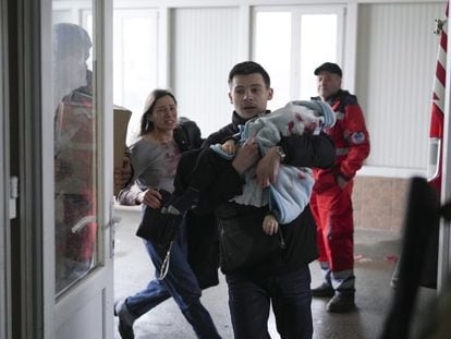 Un hombre traslada a su hijo herido a un hospital de Mariupol tras un bombardeo ruso, el sábado.