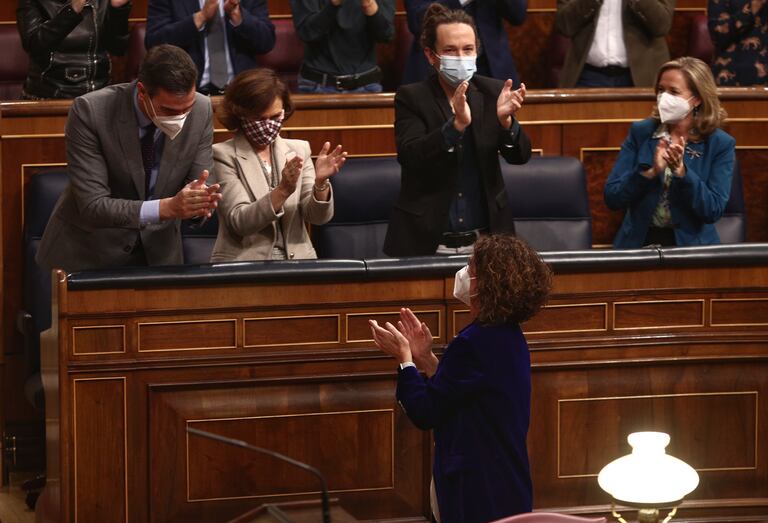 La ministra de Hacienda, María Jesús Montero, aplaudida por el presidente, Pedro Sánchez, y tres de los vicepresidentes, en el Congreso.