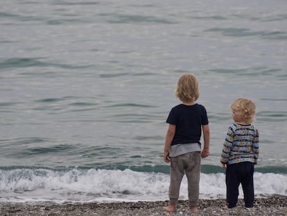 Dos niños observan el horizonte.