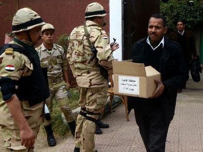 Un egipcio carga una caja con papeletas en un colegio electoral de El Cairo.