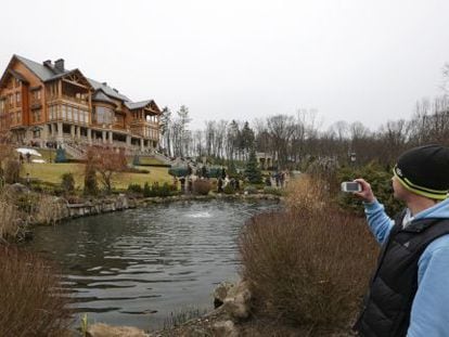 Un hombre toma fotos de la mansión de Víctor Yanukóvich a las afueras de Kiev, invadida el sábado.