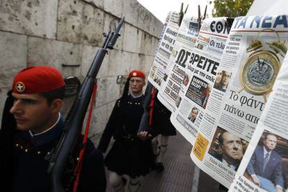 Soldados de la guardia presidencial pasan ante un puesto de periódicos ayer en Atenas.