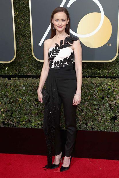 La actriz de El cuento de la criada, Alexis Bledel, quiso romper el riguroso negro de la noche con un toque de blanco en su mono palabra de honor. Oscar de la Renta firma el diseño.