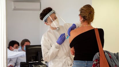 Personal sanitario vacuna a una mujer contra la covid en el recinto del antiguo hospital Son Dureta, este martes en Palma de Mallorca.