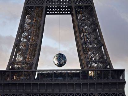 Una esfera cuelga entre el primer y el segundo piso de la torre Eiffel en París, con motivo de la COP21. 