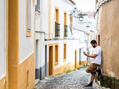 Un joven mirando su teléfono móvil en un pueblo.