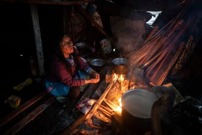 Una mujer indígena cocina en un campamento de Bogotá.