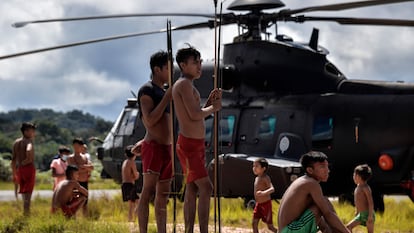 Un grupo de indígenas yanomami alrededor de un helicóptero de la Fuerza Aérea brasileña en el municipio de Alto Alegre, Estado de Roraima (Brasil).