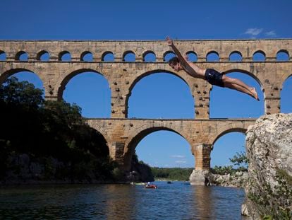 Un adolescente se zambulle en el río en Pont du Gard (Francia).