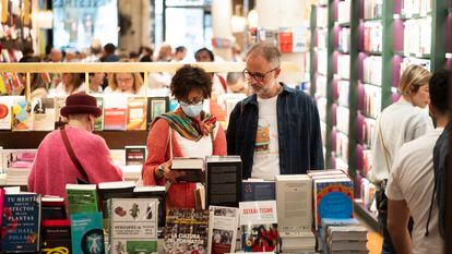 Varias personas buscan libros en una librería de Barcelona.
