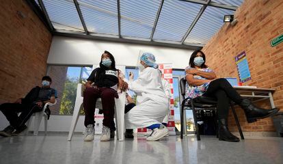Un trabajador de la salud aplica a una mujer sin hogar una inyección de la vacuna Johnson & Johnson en un refugio municipal de la ciudad de Bogotá, 2 de julio de 2021.