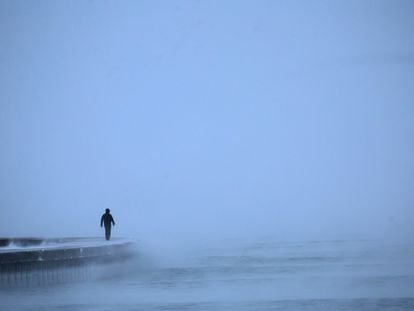 Un hombre camina a lo largo del lago Michigan al amanecer mientras las temperaturas rondan los -8 grados en Chicago.