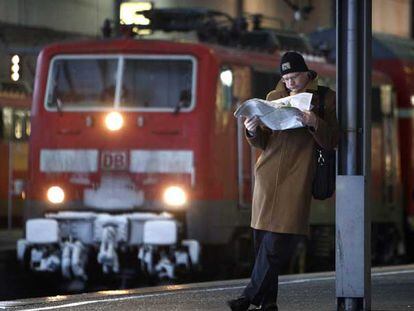 Un usuario del tren lee el periódico en la estación central de Múnich.