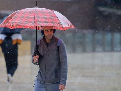 Un joven se protege de la lluvia en una calle de Málaga, el 14 de marzo.