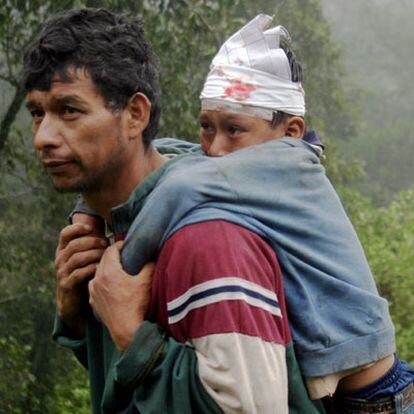 Un hombre evacua a su hijo herido en una aldea guatemalteca.