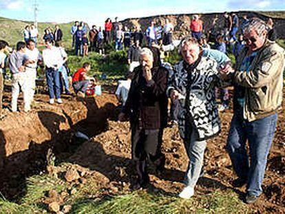 Dos ancianas que tienen enterrados familiares en la fosa común de Piedrafita de Babia pasan junto a la zanja.