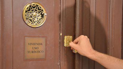 Un viajero abre la puerta de una vivienda de uso tur&iacute;stico en Madrid.