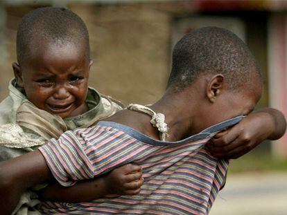 Una niña con su sobrina a cuestas busca a sus padres de los que se separó mientras huían de Kiwaqnja (este de Congo).