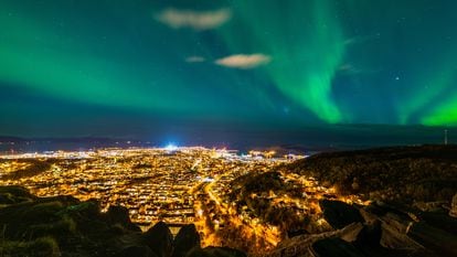 Vista de una aurora boreal sobre la ciudad noruega de Bodø.