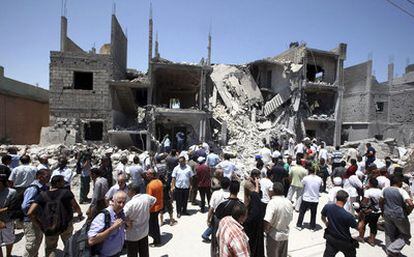 Ciudadanos libios observan los escombros de varias casas que, según las autoridades libias, fueron destruidas durante un ataque aéreo de la OTAN, en Trípoli, Libia, el pasado 18 junio.