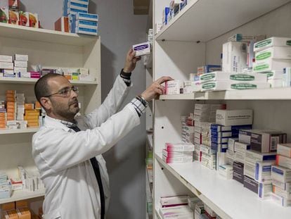 Un farmacéutico dispensa medicamentos en una farmacia de Sevilla. 