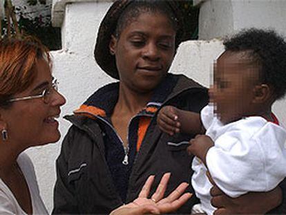 María Isabel Caro, con la niña a la que amamantó y su madre.
PLANO GENERAL - ESCENA