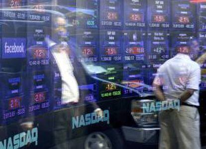 Fotografía de archivo donde se ven algunos transeúntes reflejados en una ventana con el logo de Facebook en la sede del Nasdaq en Times Square, Nueva York (NY, EE.UU.). EFE/Archivo